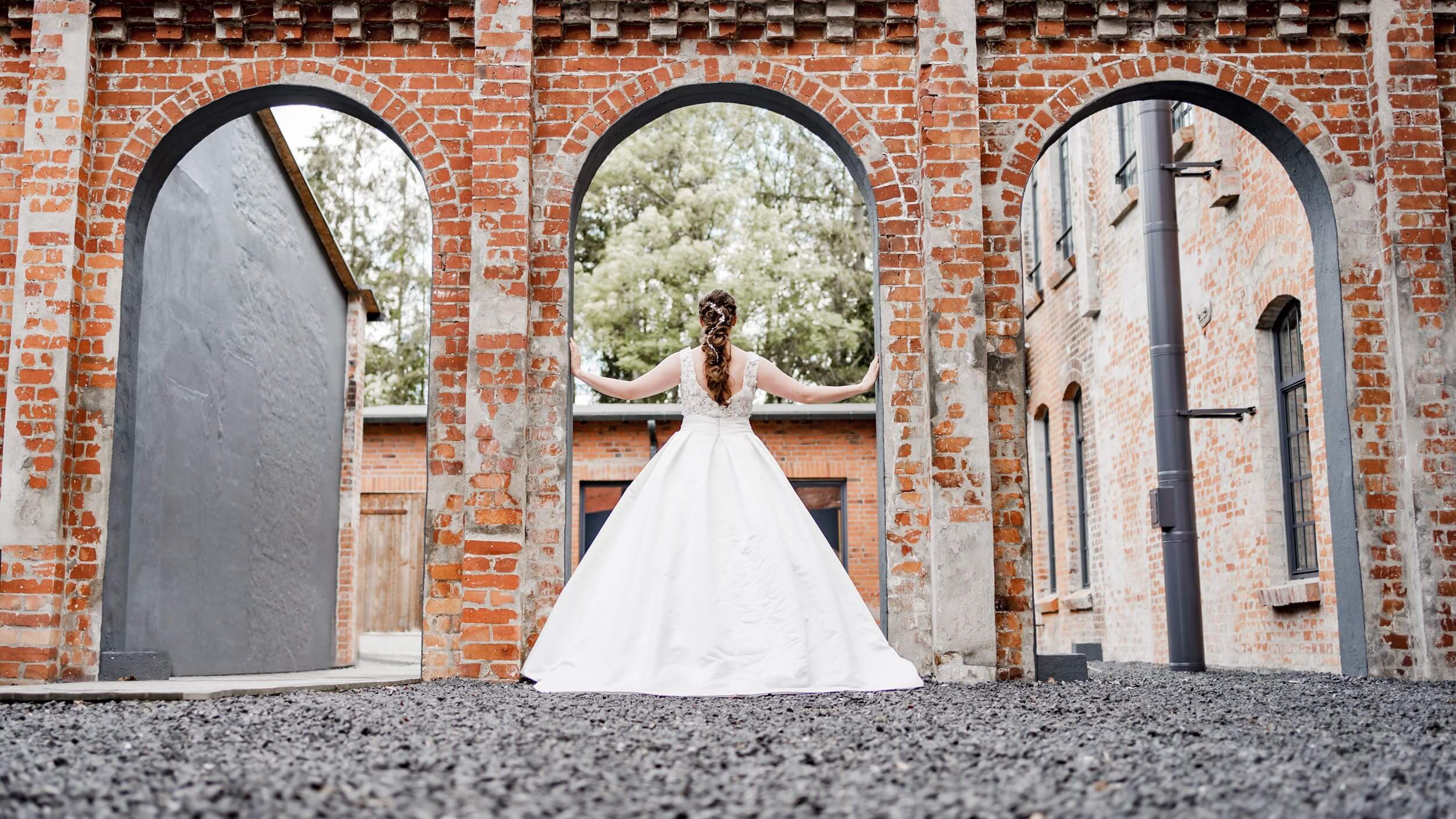 Braut mit Brautkleid im Torbogen